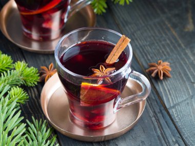 İki bardak tarçınlı kırmızı şarap, portakal ve ahşap masada yıldız anason. Noel ve yeni yıl içkisi. Boşluğu kopyala.