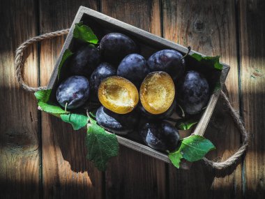 Tahta masadaki tahta kutuda dilimlenmiş erikli taze erik. Fotokopi alanı ile genel çekim