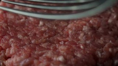 Çatal, hamburgere hazır ahşap kesme tahtasındaki çiğ sığır pirzolasının dokusunu yapıyor. Ağır çekim. Kapatın. Tam HD görüntüler