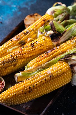 Tuzlu, kırmızı biberli ve tereyağlı ızgara mısır. Organik yiyecekler, vejetaryen yemekler. Barbekü, bbq. Mısır, mısır, tahıl. Organik gıda, sağlıklı beslenme.