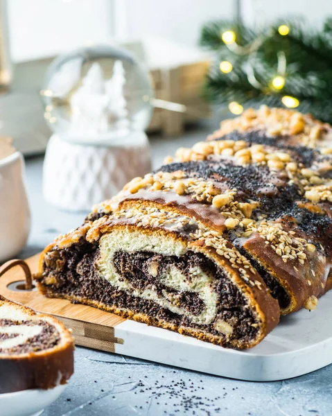 Christmas poppy seed cake, sliced poppy seed cake covered with icing and decorated with raisins and walnuts. Traditional Christmas cake in Poland. Christmas dish. Christmas eve. Xmas.