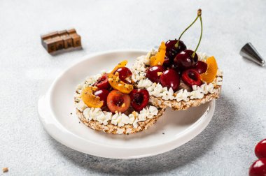 Krem peynirli pirinç keki ve beyaz arka planda böğürtlen. Sağlıklı gıda konsepti. Vejetaryen atıştırması.
