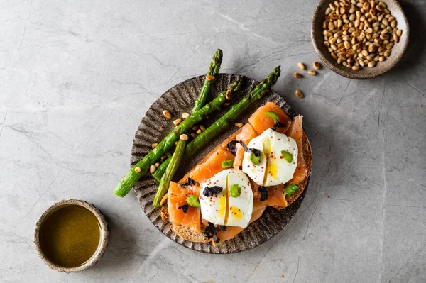 stock image Sandwiches with smoked salmon and asparagus on the light stone background, top view. Space for text. Healthy lunch.