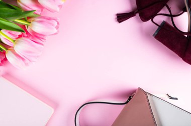 Kadın ofis masası. Çalışma odası, defter, pembe lale çiçekleri ve aksesuarları. Düz yerde, üst tarafta. Moda blog geçmişi. Kadınlar düz bir şekilde. Moda konsepti