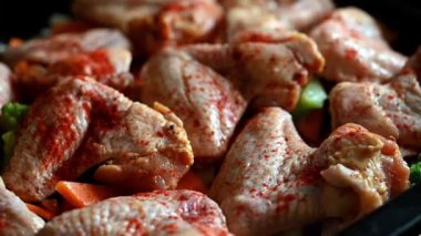 Baharatlı ve sarımsaklı çiğ tavuk kanadı pişirmek. Çiğ tavuk kanadı ve baharat. Yemek pişirme konsepti. Barbekü tavuk kanadı. BBQ eti