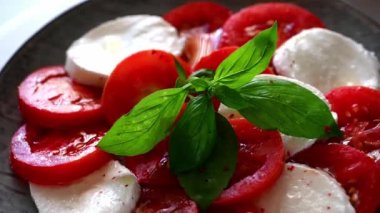 Caprese salatası. Mozzarella ve fesleğen yapraklı domates salatası. İtalyan mutfağı. Akdeniz yemeği. Organik yiyecekler. İtalyanca başlık