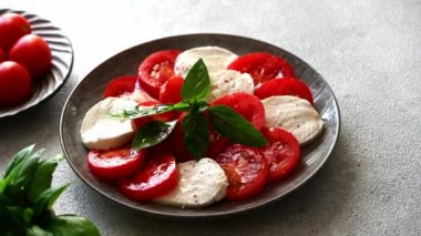 Caprese salatasına mozzarella, domates ve fesleğen ile zeytin yağı dök. Klasik caprese salatası. İtalyan Caprese. Geleneksel İtalyan yemekleri..