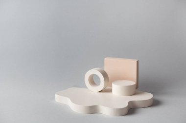 Ürün sunumu için minimum soyut kozmetik arka plan. Gri arka planda kozmetik şişe podyumu. Pastel renkler, geometrik formlarla biçimlendirilmiş kompozisyon. Minimum konsept. Ürün modeli..