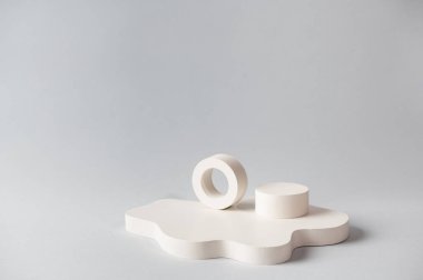 Ürün sunumu için minimum soyut kozmetik arka plan. Gri arka planda kozmetik şişe podyumu. Pastel renkler, geometrik formlarla biçimlendirilmiş kompozisyon. Minimum konsept. Ürün modeli..
