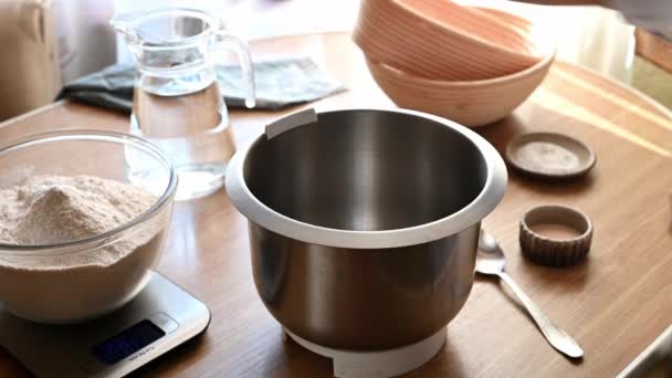 Las manos femeninas vierten harina de un plato en un tazón transparente de escamas de cocina. Preparación para preparar la masa. Ingredientes para hacer masa de pan casera. Comida confortable. Haciendo masa — Vídeo de stock