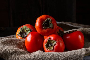 Ahşap arka planda olgun hurma. hurma eriği ya da Sharon meyvesi. Kaki hurma meyvesi. Yerel yemek..