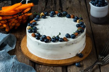 Koyu ahşap arka planda cevizli ve yaban mersinli havuçlu kek. Yerel yemek. Geleneksel Amerikan pastası. Şükran Günü için pasta. Sonbahar pastası
