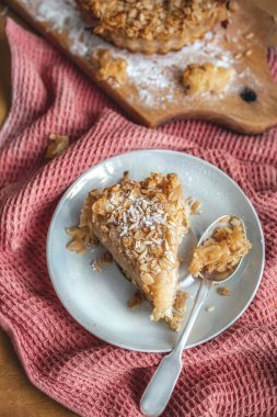 Düz manzaranın yulaflı turtası yeni pişmiş. Pembe havluyla yakın plan, kaşıkla. Kopyalama uzayı. Dikey görünüm.