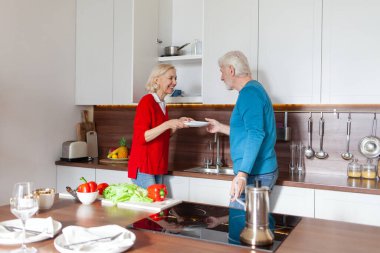 Yaşlı bir çift mutfağı temizliyor ve bulaşıkları rafa koyuyor. Bu arada büyükannen ve büyükbaban bulaşıkları yıkıyor ve birlikte ev işi yapıyorlar.