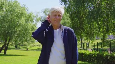 Yaşlı beyefendi parkta düşünür, unutur ve omuz silker, belirsiz gri saçlı, kafası karışmış, açık havada hatırlayamaz.