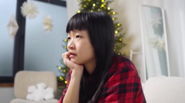 Asyalı genç bir kadın televizyon seyrediyor, umut ve futbol hakkında endişeleniyor, kanepede oturup film seyrediyor ve gergin ve heyecanlı hissediyor.