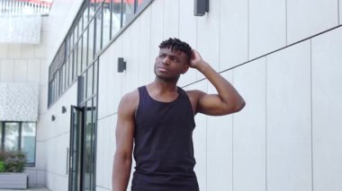 Afrika kökenli Amerikalı bir adam sokakta kafasını kaşıyıp düşünüyor, atletik düşünceli bir adam çözüm planları yapıyor ve bilmiyor.