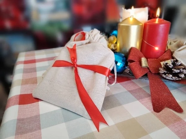 Kırmızı ve altın mumlu Noel süsleri, hediye kutuları ve kırmızı fiyonklar