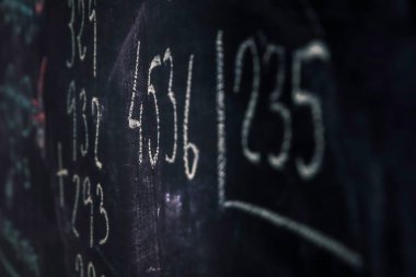 Tebeşirle yazılmış birincil matematik formülleri olan karatahta. Çocukluk eğitimi konsepti. Seçici odak