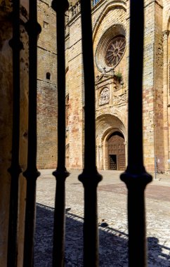 Siguenza Katedrali 'nin ana girişinin görüntüsü. Dış kapının demir parmaklıkları görüntüyü çerçeveler. Ortaçağ İspanyol mimarisinin tarihi anıtı.