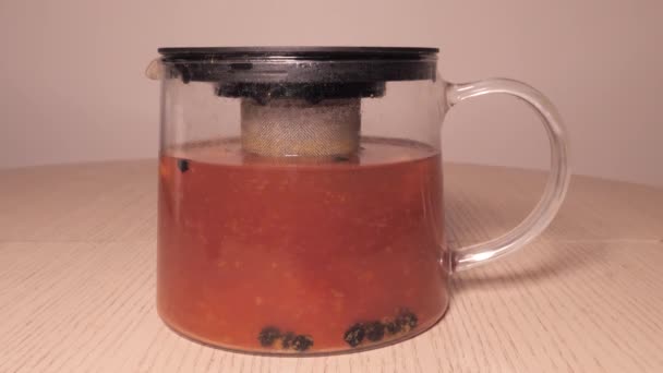 Brewing tea in a jug - daun teh yang mengapung di dalam teh. jahe dan lemon currant buckthorn laut — Stok Video