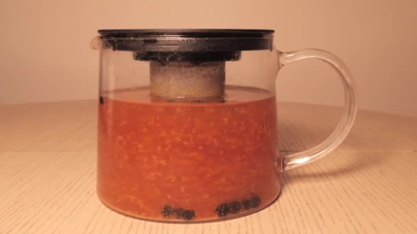 Brewing tea in a jug - tea leaves floating in tea. ginger and lemon sea buckthorn currant — Stock Video