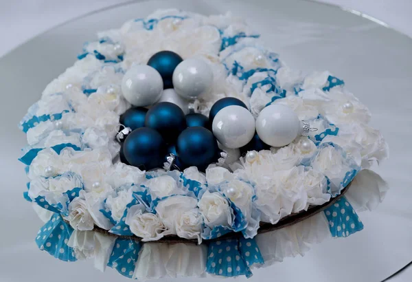 El yapımı kağıt bir çelengin içinde beyaz ve mavi Xmas topları.