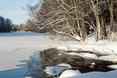 Donmuş gölü ve karla kaplı taşlarla dolu açık akıntıları olan bir arazi.