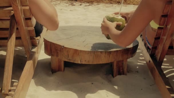 Pasgetrouwden kokosnoten drinken op het strand — Stockvideo