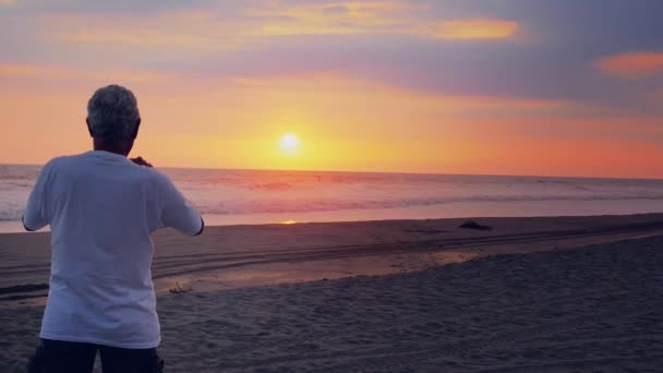 Homem sênior contemplando o belo pôr do sol — Vídeo de Stock