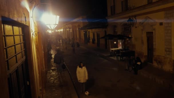 Люди, гуляющие ночью по улице — стоковое видео
