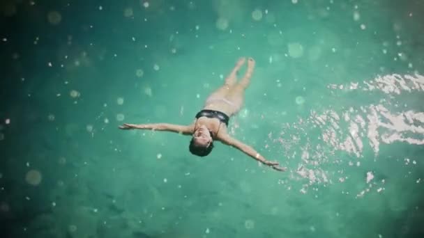 Mujer flota y juega en una piscina — Vídeo de stock