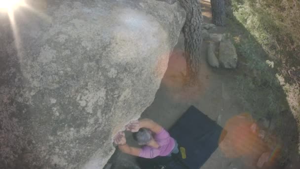 Männchen klettert auf einen riesigen Felsen — Stockvideo