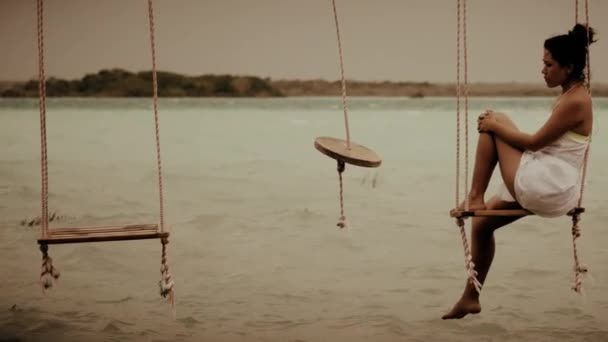 Mulher sentada em um balanço lagoa — Vídeo de Stock