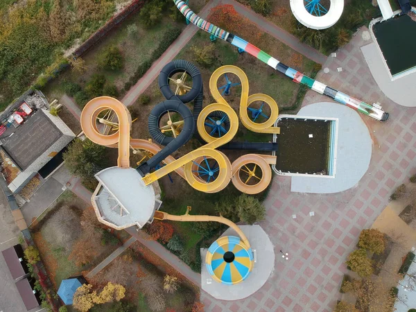 Aerial photo of small aqua park with colorful tubes, view from above, abandoned, nobody.