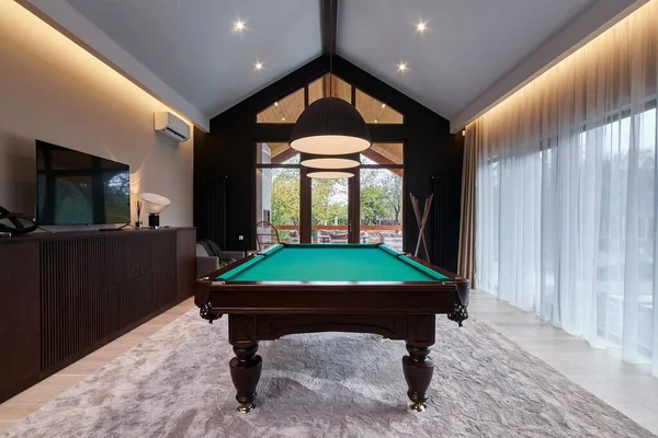 modern billiard room with a beautiful table and large windows. Nobody.
