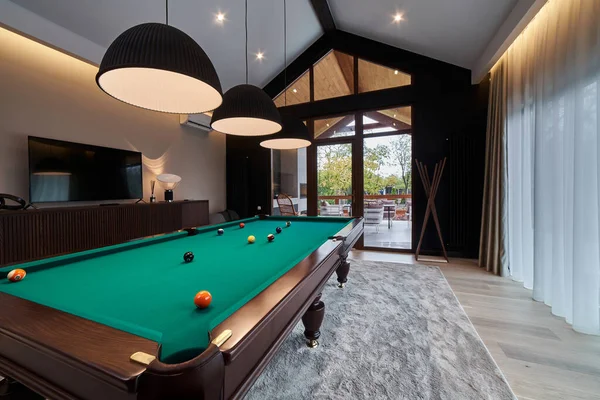 modern billiard room with a beautiful table and large windows. Nobody.