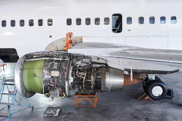aircraft engine servicing - opened panels of a large engine of parked aircraft. nobody