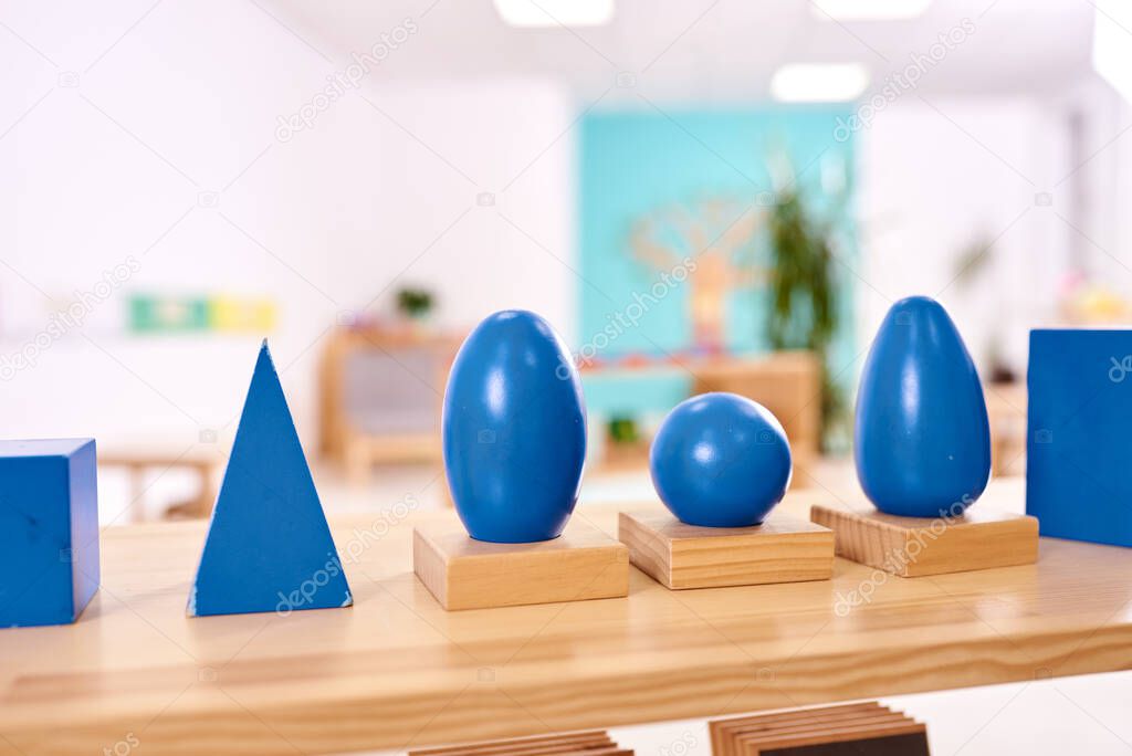Light class in Montessori kindergarten. The blue Montessori geometric solids in the foreground. nobody.