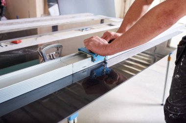 Seramik kesici kullanarak seramik fayanslar kesen inşaat işçisi