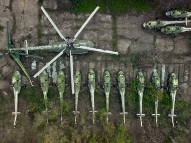 Old abandoned airfield with abandoned helicopters. Aerial view from a drone clipart