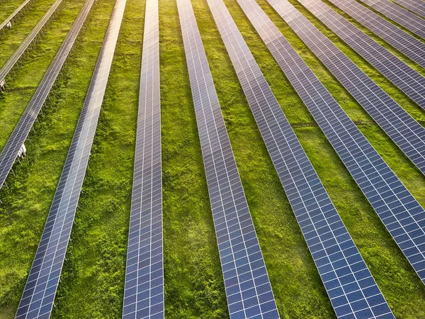 Güneşli bir günde yeşil çayırdaki güneş enerjisi santralinin havadan görünüşü.