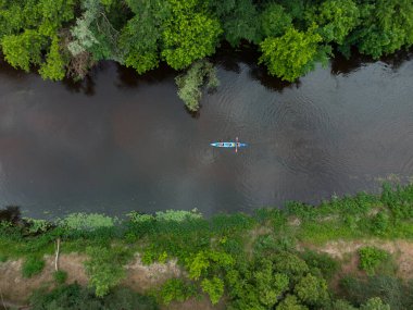Bir yaz günü bir orman nehrinde seyahat eden büyük bir kano grubunun hava görüntüsü.