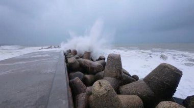 Powerful storm waves crashing against a pier, first-person view of dramatic ocean spray and rough sea.