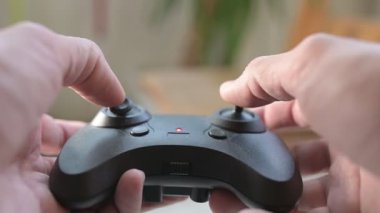 Oyuncak bir helikopter için uzaktan kumanda kullanan ellerin yakın çekimi. Kapalı bir ortamda klik ve motor sesleri ile joystickleri hareket ettiriyor..