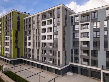 Renkli cepheli, geniş pencereli ve balkonlu, çağdaş konut mimarisi sergilenen yeni tamamlanmış modern apartman manzarası..