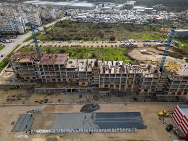 İskelelerle kaplı çok katlı bir konut inşaatı, dış duvarları bitiren işçiler, detaylı bir kentsel gelişim sahnesinde yakalandı..