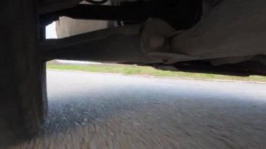 Arabanın altına monte edilmiş bir aksiyon kamerasından alınan düşük açılı POV sürücü videosu, güçlü yol hareketleriyle süspansiyon ve tekerlek hareketlerini gösteriyor. Otomotiv iniş alanı görünümü, hız, araç dinamiği, seyahat ve ulaşım.