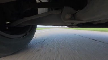 Arabanın altına monte edilmiş bir aksiyon kamerasından alınan düşük açılı POV sürücü videosu, güçlü yol hareketleriyle süspansiyon ve tekerlek hareketlerini gösteriyor. Otomotiv iniş alanı görünümü, hız, araç dinamiği, seyahat ve ulaşım.