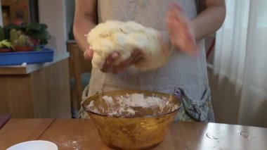 Ev mutfağında hamuru kaseye karıştıran kadın. Malzeme ve hamur yoğurma, ev yapımı pişirme, sıfırdan pişirme, ev yemeği hazırlama konsepti.